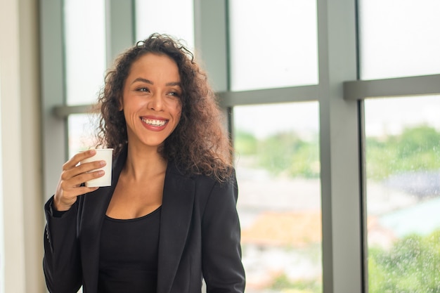 Sorriso de empresária feliz na hora do café no escritório