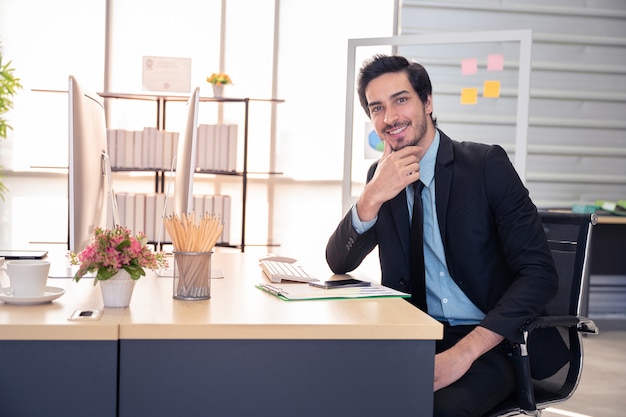 Sorriso de empresário durante o trabalho com o computador no escritório