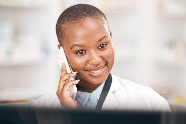 Sorriso de farmácia e mulher falando ao telefone enquanto lê informações Africano ou farmacêutico em smartphone para consulta de telessaúde ou atendimento ao cliente e conselhos de saúde