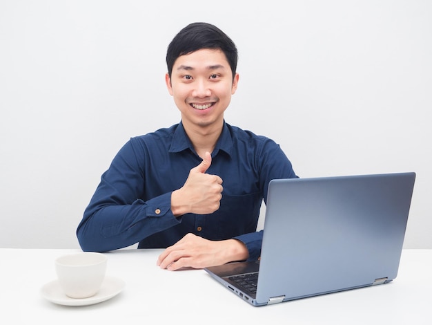 Sorriso de homem alegre e polegar para cima com seu laptop em cima da mesa