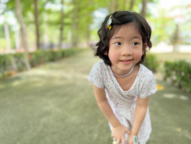 Sorriso de menina bonitinha com bela pose no jardim com espaço de cópia