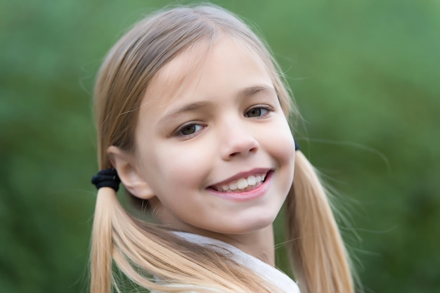 Sorriso de menina na infância de fundo natural