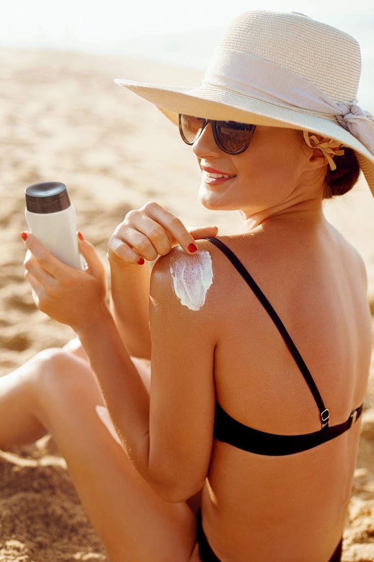 Foto sorriso de mulher bonita aplicando protetor solar no ombro skincare corpo proteção solar protetor solar
