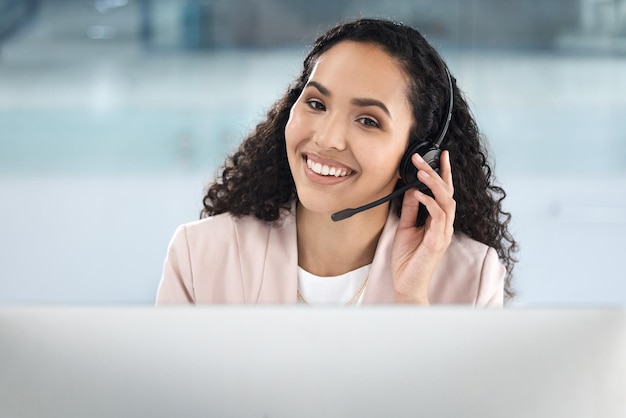 Foto sorriso de mulher de call center e computador no escritório para suporte técnico de atendimento ao cliente e conselhos de ti com telemarketing voip crm ou agente com microfone de fone de ouvido e consultoria com pc no help desk