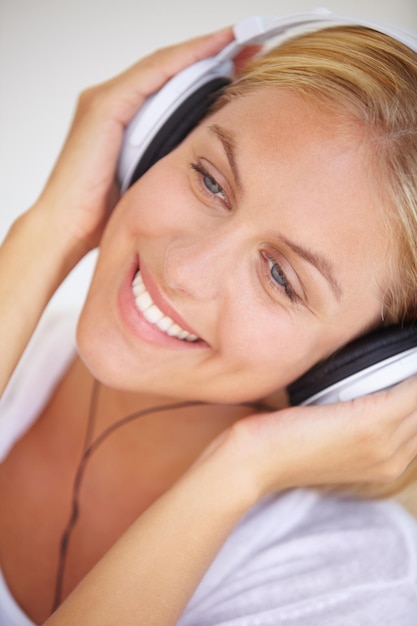 Foto sorriso de mulher feliz e fones de ouvido para ouvir música liberdade e sem fio para diversão em closeup rosto de pessoa feminina e excitação para a tecnologia com rádio de podcast ou serviço de streaming para relaxar