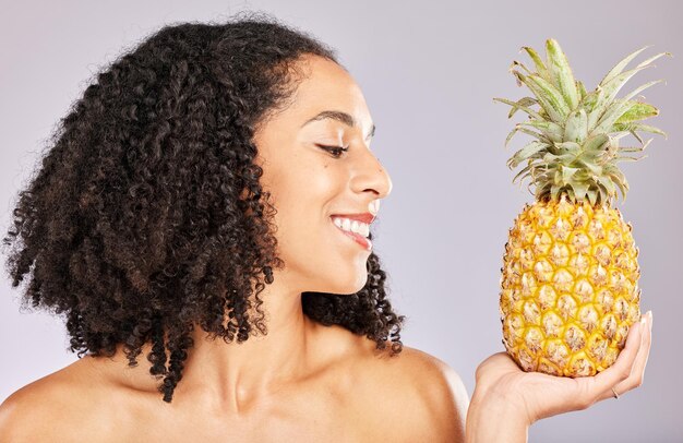 Sorriso de mulher negra de abacaxi e frutas tropicais amarelas para dieta de vitamina c e bem-estar Fundo de estúdio isolado e nutrição para desintoxicação, perda de peso e brilho da pele com frutas orgânicas saudáveis