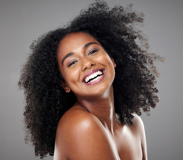 Sorriso de mulher negra e cabelo para maquiagem facial e feliz com beleza afro e cosméticos em retrato de estúdio Modelo felicidade ou cuidados com a pele com brilho cosmético ou brilho para cuidados com os cabelos saudáveis ou bem-estar