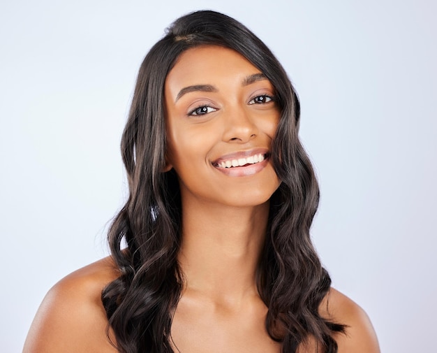 Foto sorriso de retrato de mulher e cabelos cacheados para tratamento de salão de queratina ou brilho contra um fundo de estúdio branco feliz modelo feminino isolado sorrindo para penteados saudáveis ou cosméticos de beleza