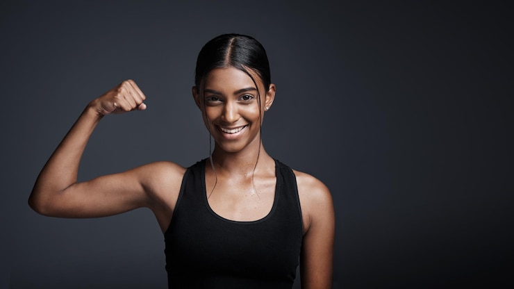 Foto sorriso de retrato e mulher flexionando o bíceps no estúdio isolado em um espaço de maquete de fundo preto forte atleta feliz e feminina com força de braço muscular e fisiculturista pronta para treino de fitness
