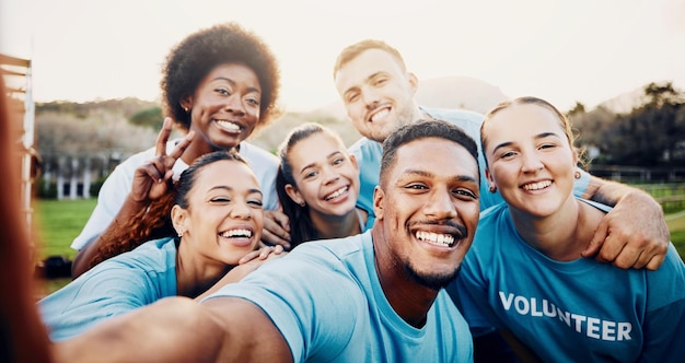 Sorriso de retrato e selfie de grupo de voluntários ao ar livre para caridade de mudança climática, limpeza e reciclagem, serviço comunitário do Dia da Terra e pessoas felizes rindo e tirando fotos com sinal de paz no parque