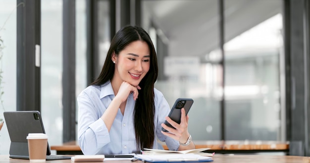 Sorriso de retrato linda mulher asiática de negócios com mesa de escritório trabalhando usando computador telefônico