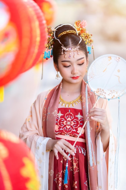 Sorriso de retrato Menina asiática bonitinha vestindo trajes chineses e com decoração de fãs chineses para o festival do ano novo chinês celebra a cultura da china no santuário chinês Lugares públicos na Tailândia