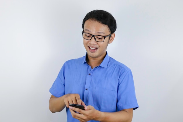 Sorriso e rosto feliz de jovem asiático com telefone na mão Conceito de modelo de publicidade com camisa azul