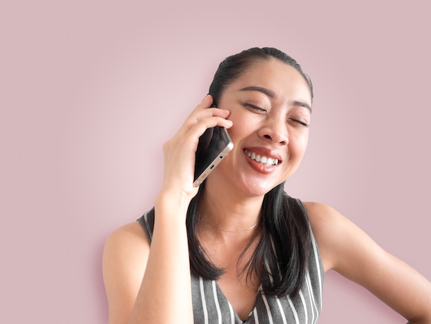 Sorriso e telefonema de fala da mulher asiática alegre no smartphone.