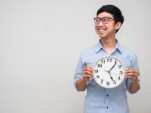 Sorriso feliz do empresário asiático segurando o gesto do relógio analógico parecendo isolado