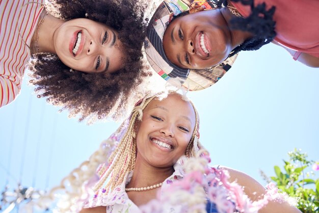Foto sorriso feliz e amigos da geração z se reúnem durante as férias de verão na cidade da califórnia com céu azul por baixo relaxe em quadrinhos e retrato facial de um grupo de mulheres africanas em férias juntos