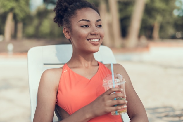 Sorriso mulher está bebendo e descansando no rio