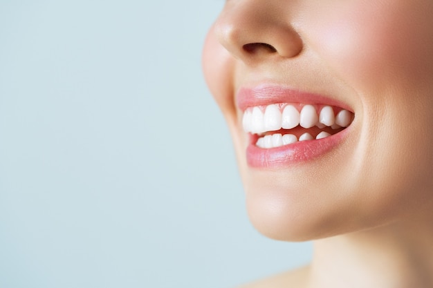 Foto sorriso perfeito de dentes saudáveis de uma jovem. clareamento dos dentes. atendimento odontológico, conceito de estomatologia.