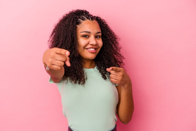 Foto sorrisos alegres de jovem mulher afro-americana, apontando para a frente.