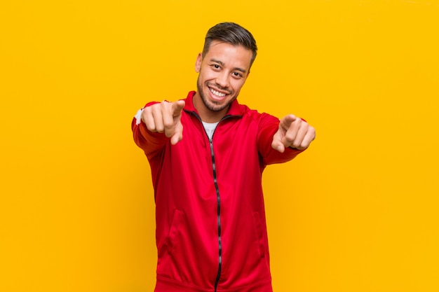 Sorrisos alegres do homem filipino novo da aptidão que apontam para frontear.