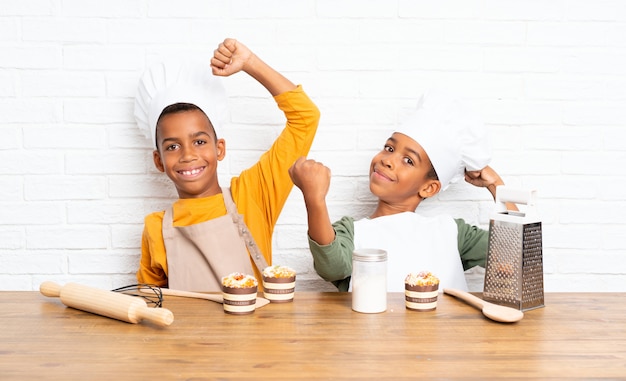 Sorte dois irmãos afro-americanos crianças vestidas como chef