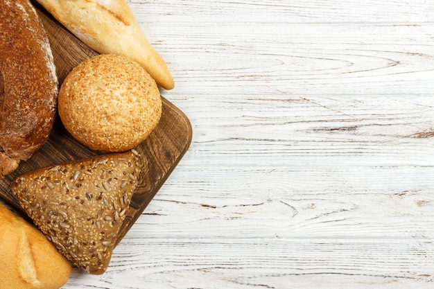 Sortido de pão assado na mesa de madeira branca