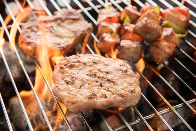 Foto sortido deliciosa carne grelhada sobre as brasas em um churrasco.