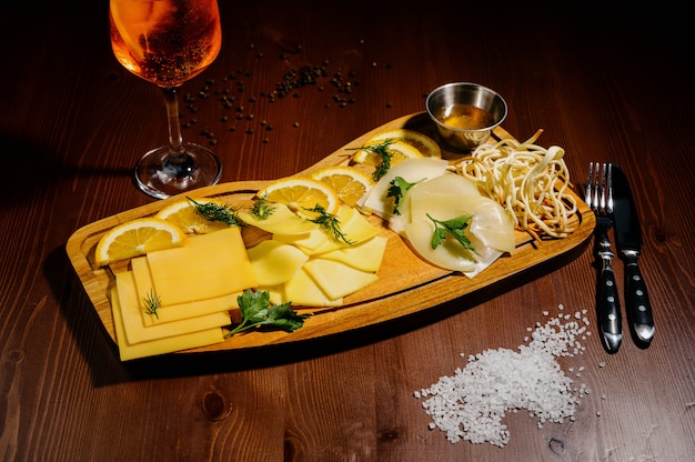 Sortidos diferentes tipos de queijo na placa de madeira.