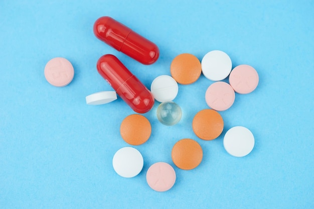 Sortierte pharmazeutische Medizinpillen, Tabletten und Kapseln über blauem Hintergrund x9