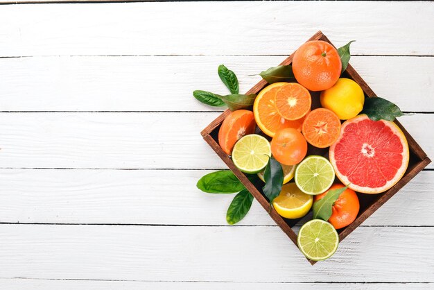 Sortierte Zitrusfrüchte in einer Holzkiste Orange Mandarine Grapefruit Zitrone Auf einem hölzernen Hintergrund Ansicht von oben Kopieren Sie Platz