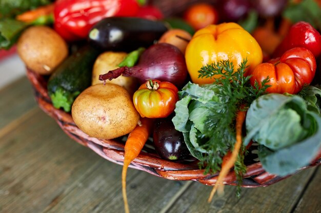 Sortiment an frischem Gemüse in einem Korb, biologisch gesund, Bio-Lebensmittel auf Holzhintergrund, Landmarktstil, Gartenprodukte, Diät-Gemüse-Lebensmittel, sauberes Essen.