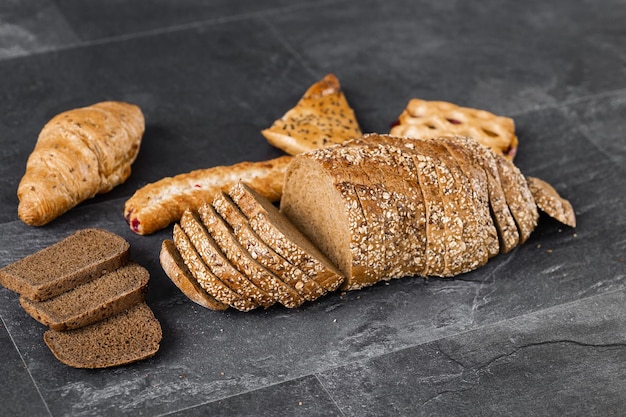 Sortiment von frisch gebackenem Brot auf dunklem Hintergrund Weiß- und Roggenbrötchen mit Kopierplatz