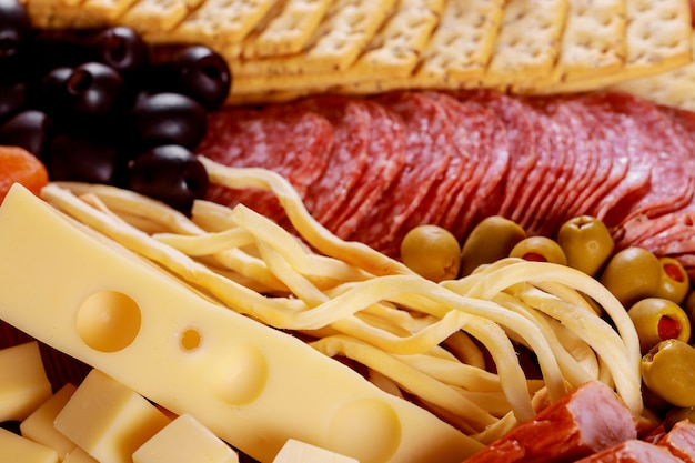 Sortiment von Käse und Oliven auf Salami-Wurst-Tabelle