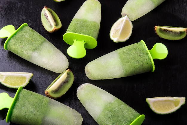 Sorvete caseiro verde na superfície preta, gelo de frutas com kiwi e limão,