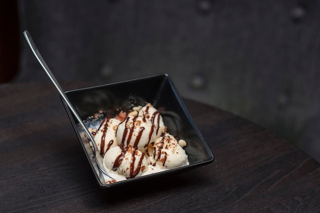 Sorvete com calda de chocolate em uma tigela sobre uma mesa em uma cafeteria