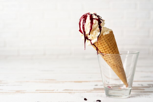 Sorvete de baunilha em cone com molho de cereja