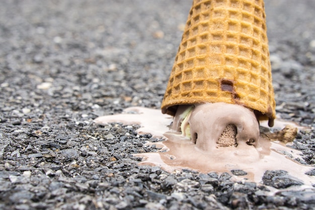 sorvete de chocolate caiu no chão de concreto e derreteu no chão.