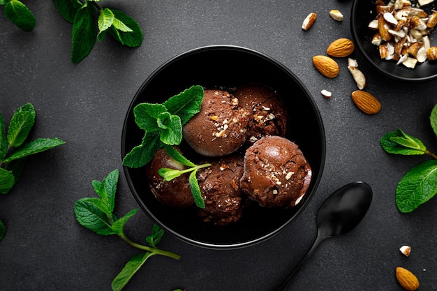 Sorvete de chocolate com amêndoas servido em tigela na vista superior de fundo preto