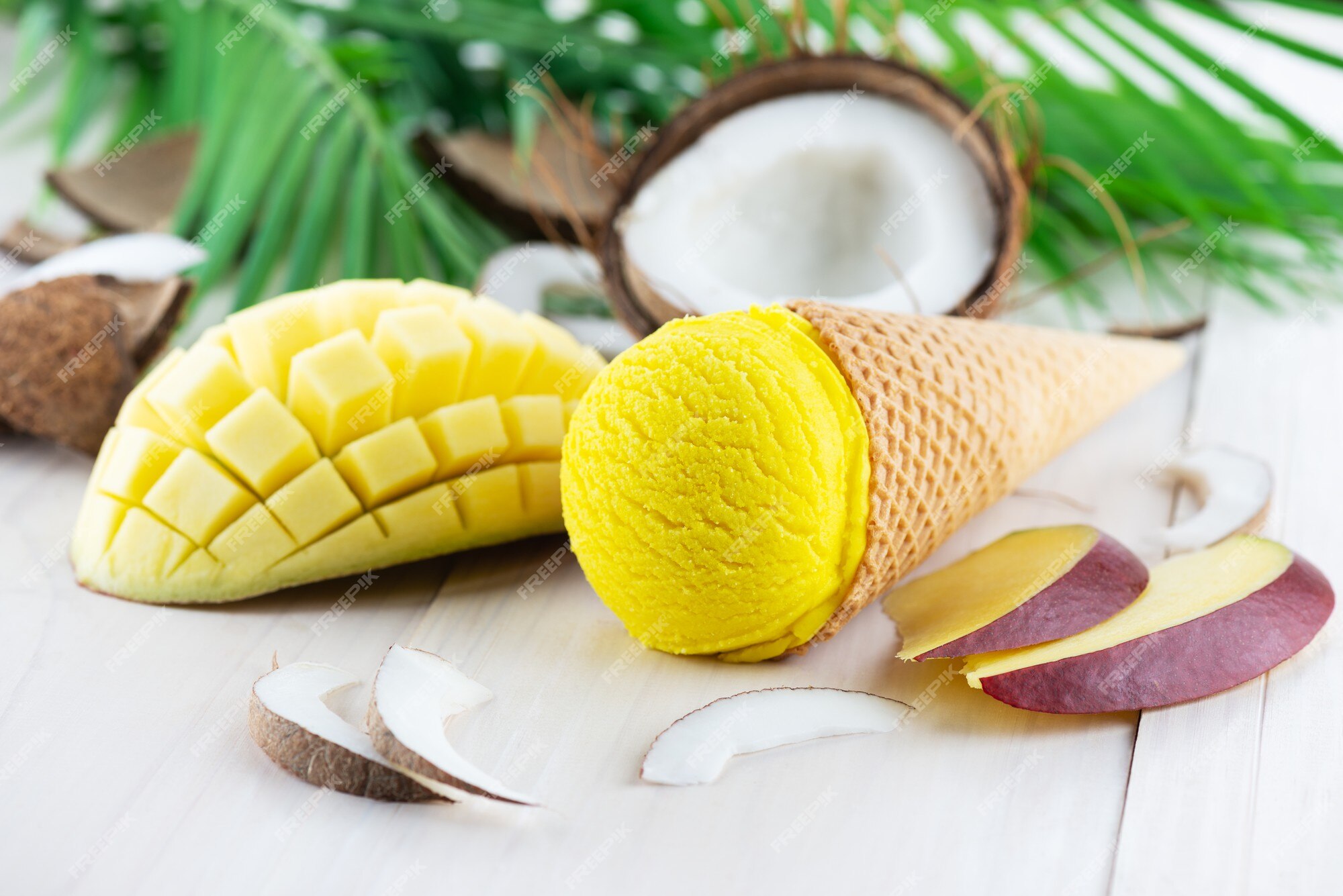 Foto de Uma Bola De Sorvete Amarelo Em Uma Casca De Coco Manga E Coco Em  Uma Folha De Palmeira Sobre Um Fundo Cinza Do Concreto Vista Superior e  mais fotos de