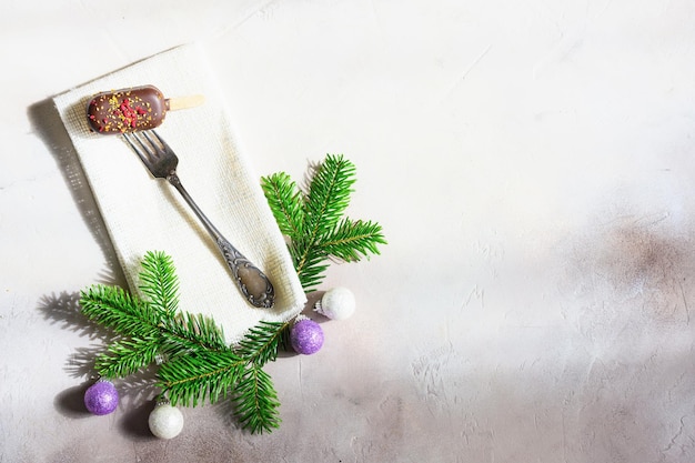 Sorvete no garfo antigo e decoração de natal em fundo cinza