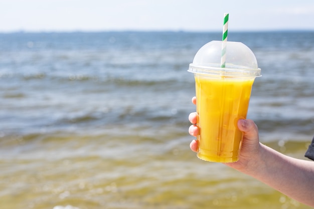 Sorvete, suco, limonada amarela na praia, costa do mar, laranja, bebida refrescante, relaxar