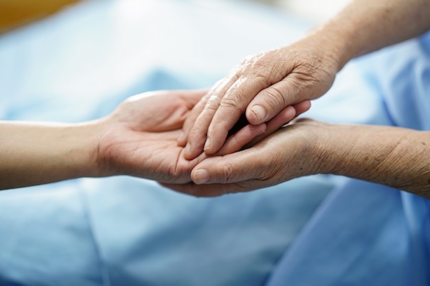 Sostener las manos asiáticas mayores o ancianos anciana mujer paciente con amor