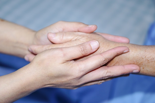 Sostener las manos tocando Asia mayor o anciano anciana mujer paciente con amor, cuidado.