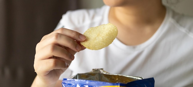 Sostenga a mano papas fritas con bolsa de bocadillos