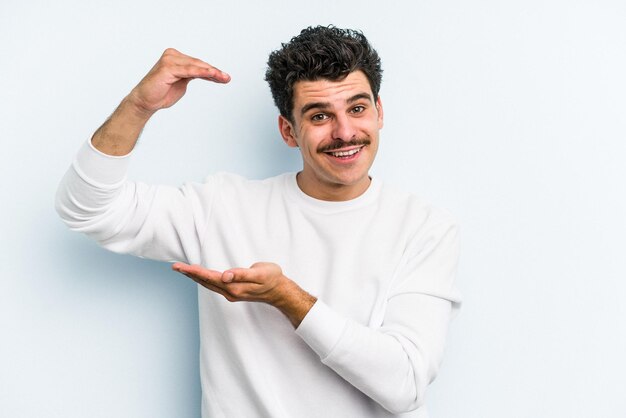 Sosteniendo algo pequeño con los dedos índices sonriendo y confiado