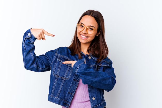 Sosteniendo algo pequeño con los dedos índices sonriendo y confiado