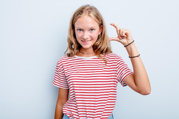 Sosteniendo algo pequeño con los dedos índices sonriendo y confiado