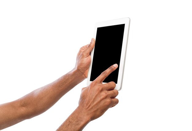 Sosteniendo y apuntando en la pantalla en blanco de la tableta digital. Hombre afroamericano con dispositivo con pantalla en blanco, espacio de copia para publicidad, aislado sobre fondo blanco.