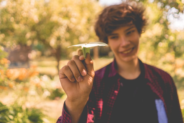 Sosteniendo un avión de papel en un concepto de éxito de vacaciones de verano