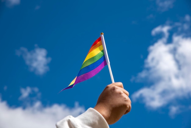 Sosteniendo la bandera del arco iris del símbolo del orgullo gay